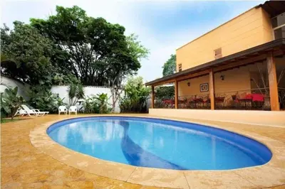 a swimming pool in the yard of a house at Hotel Portales Del Campestre in Medellín