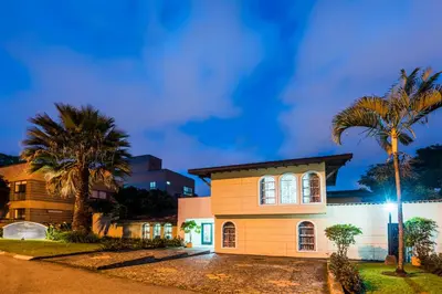 a house with palm trees in front of it at Hotel Portales Del Campestre in Medellín