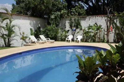 a swimming pool with two chairs and two lawn chairs at Hotel Portales Del Campestre in Medellín
