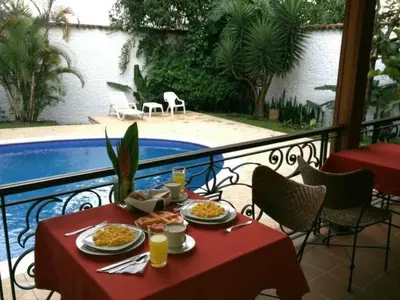 a table with plates of food on a balcony at Hotel Portales Del Campestre in Medellín