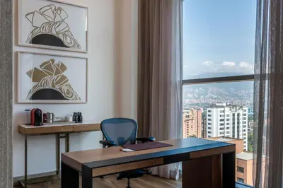 a desk and a chair in a room with a window at Medellin Marriott Hotel in Medellín