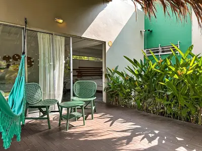 a patio with chairs and a hammock and plants at Los Colores Ecoparque in Doradal
