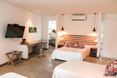 a hotel room with two beds and a television at Los Colores Ecoparque in Doradal
