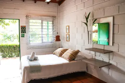 a bedroom with a bed with a mirror and a window at Los Colores Ecoparque in Doradal