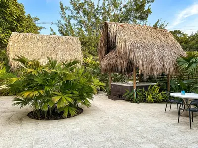 a patio with a table and straw umbrellas and plants at Los Colores Ecoparque in Doradal
