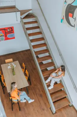 two women sitting at a table on a staircase at Travelers Orange Suites in Medellín