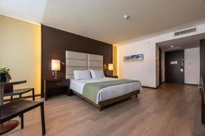 a hotel room with a bed and a desk at Hotel Estelar Milla De Oro in Medellín