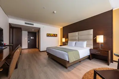 a hotel room with a bed and a desk at Hotel Estelar Milla De Oro in Medellín