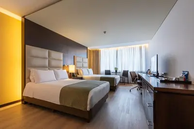 a hotel room with a bed and a desk at Hotel Estelar Milla De Oro in Medellín