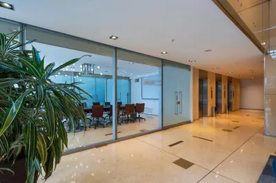 an office lobby with glass walls and a table at Hotel Estelar Milla De Oro in Medellín