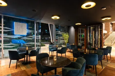 a restaurant with tables and chairs and windows at Hotel Estelar Milla De Oro in Medellín