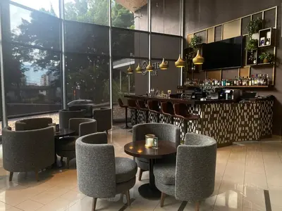 a restaurant with tables and chairs and a bar at Hotel Estelar Blue in Medellín