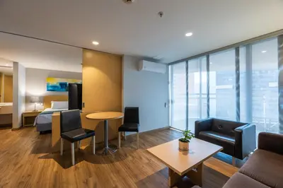 a hotel room with a bed and a table and chairs at Hotel Estelar Blue in Medellín