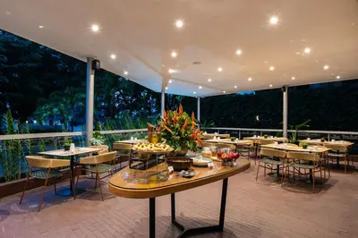 a restaurant with tables and chairs on a balcony at Hotel Estelar Blue in Medellín