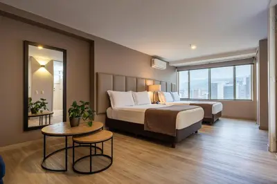 a hotel room with a large bed and a table at Estelar Apartamentos Medellin in Medellín