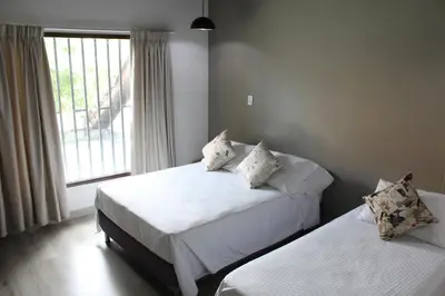 two beds in a room with a window at Hotel Boutique Plaza in Medellín