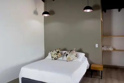 a bedroom with a bed with white sheets and two pillows at Hotel Boutique Plaza in Medellín
