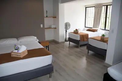 a hotel room with two beds and a window at Hotel Boutique Plaza in Medellín