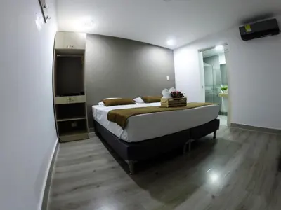 a bedroom with a bed and a flat screen tv at Hotel Boutique Plaza in Medellín