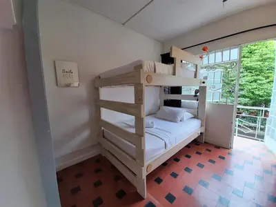 a bedroom with bunk beds in a room with a window at Noah boutique hostels Medellín in Medellín