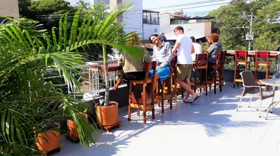 a group of people sitting at tables on a patio at Noah boutique hostels Medellín in Medellín