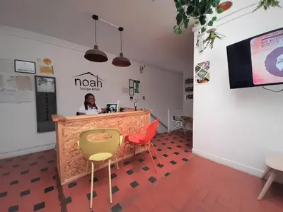 a woman sitting at a counter in a room with chairs at Noah boutique hostels Medellín in Medellín