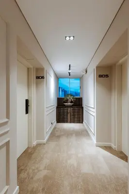 an empty hallway with white walls and a large window at 1616 Hotel in Medellín