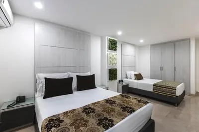 a bedroom with two beds and a window at Hotel Madeiro in Medellín
