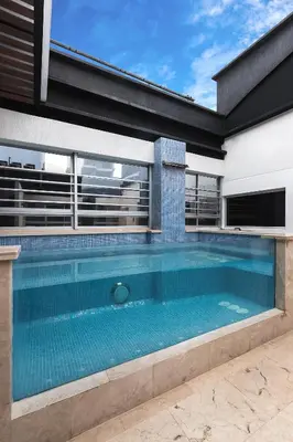 a swimming pool in front of a house at Hotel Madeiro in Medellín