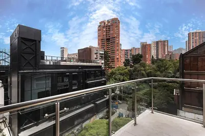 a balcony with a view of a city with tall buildings at Hotel Madeiro in Medellín