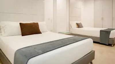 a bedroom with two beds and a couch at Hotel Madeiro in Medellín