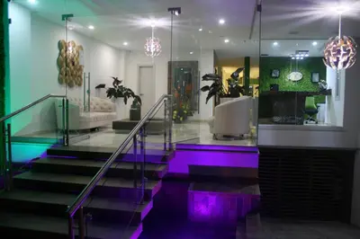 a lobby with purple and green lights on the stairs at Hotel Madeiro in Medellín
