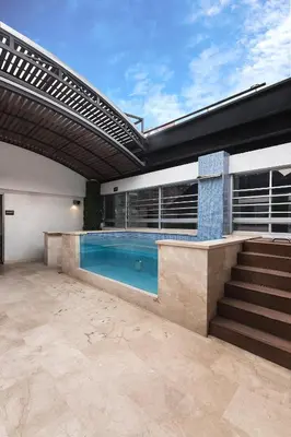an indoor swimming pool in a house with an awning at Hotel Madeiro in Medellín
