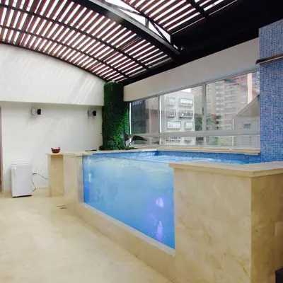 a large indoor swimming pool in a building at Hotel Madeiro in Medellín
