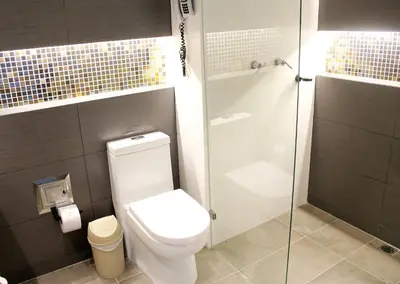 a bathroom with a toilet and a glass shower at GHL Hotel Portón Medellín in Medellín