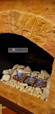 a stone oven with rocks and lights in it at El Quijote Apartahotel in Jericó