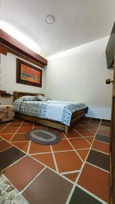 a bedroom with a bed in the corner of a room at El Quijote Apartahotel in Jericó