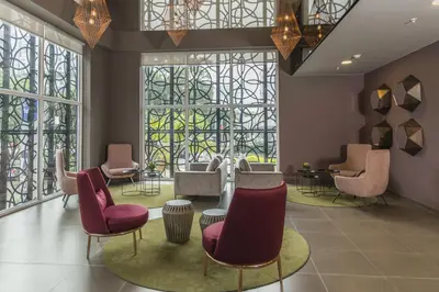 a waiting room with chairs and tables and windows at City Express Plus by Marriott Medellín Colombia in Medellín