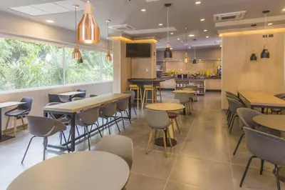 a restaurant with tables and chairs in a cafeteria at City Express Plus by Marriott Medellín Colombia in Medellín