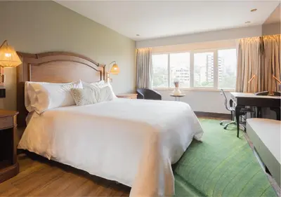 a hotel room with a large white bed and a desk at InterContinental Medellin - Movich by IHG in Medellín