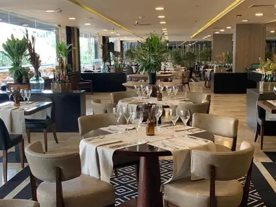 a restaurant with tables and chairs with wine glasses at InterContinental Medellin - Movich by IHG in Medellín