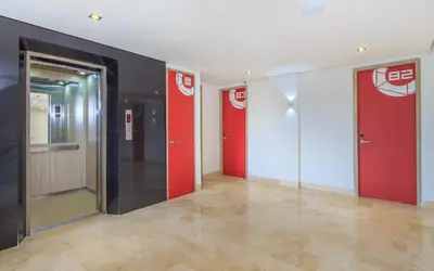 a hallway with two elevators with red and white walls at Obo Hotel in Medellín
