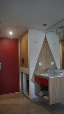 a kitchen with a sink and a red door at Obo Hotel in Medellín
