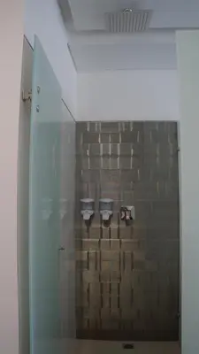 a glass wall in a bathroom with a brick wall at Obo Hotel in Medellín