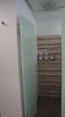 a bathroom with a glass door and a wooden wall at Obo Hotel in Medellín