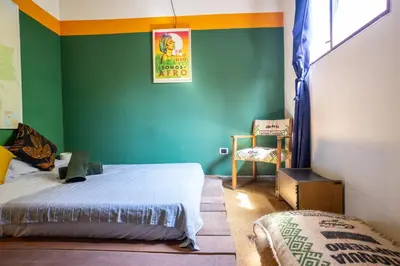 a bedroom with a bed and a green wall at Oasis en el corazón de Medellin, Laureles in Medellín