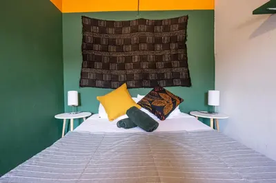 a bedroom with a bed with a headboard and two tables at Oasis en el corazón de Medellin, Laureles in Medellín