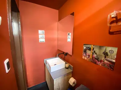an orange bathroom with a sink and a mirror at Oasis en el corazón de Medellin, Laureles in Medellín