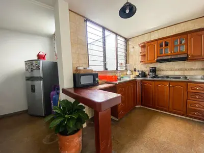 a kitchen with wooden cabinets and a refrigerator at Oasis en el corazón de Medellin, Laureles in Medellín