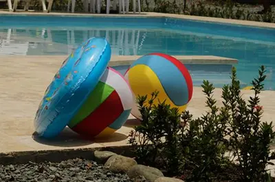 two colorful volley balls sitting next to a swimming pool at Finca Hotel Guali Santafe in Santa Fe de Antioquia